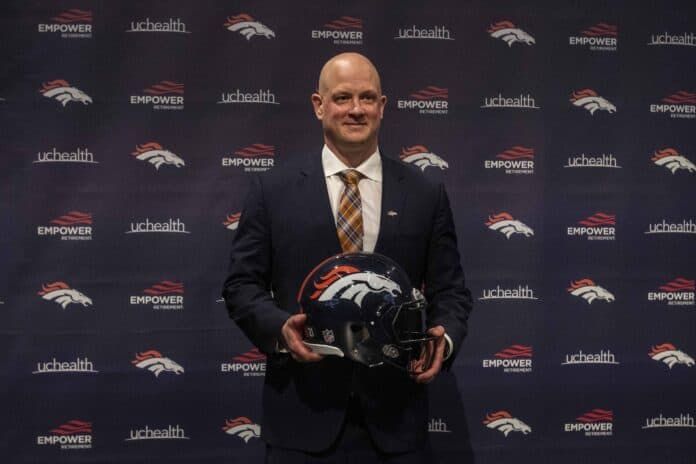 Nathaniel Hackett holding a Broncos helmet at his introductory press conference