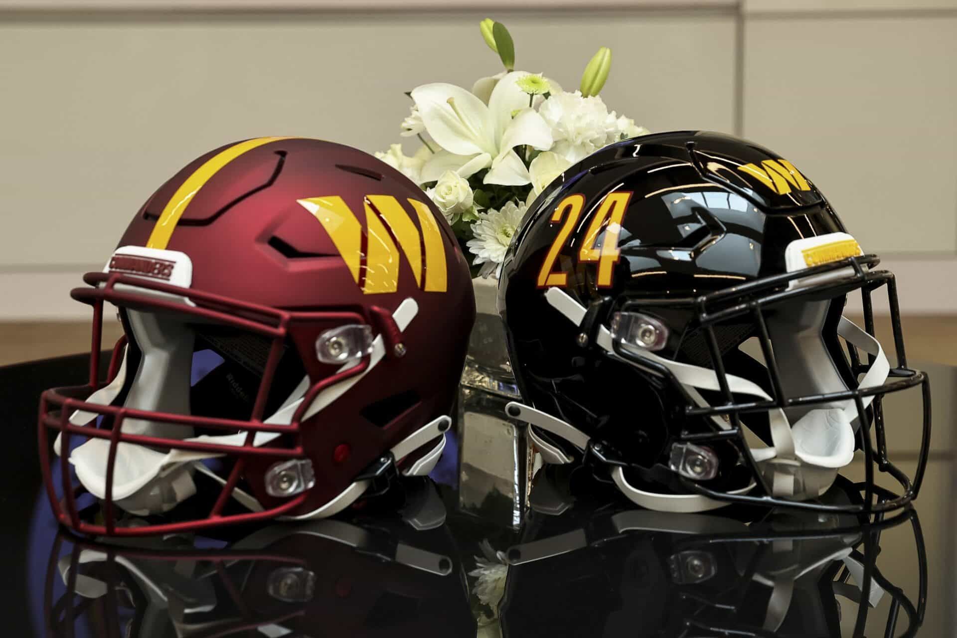 Helmets of the Washington Commanders displayed on a table at Inova Sports Performance Center Auditorium.