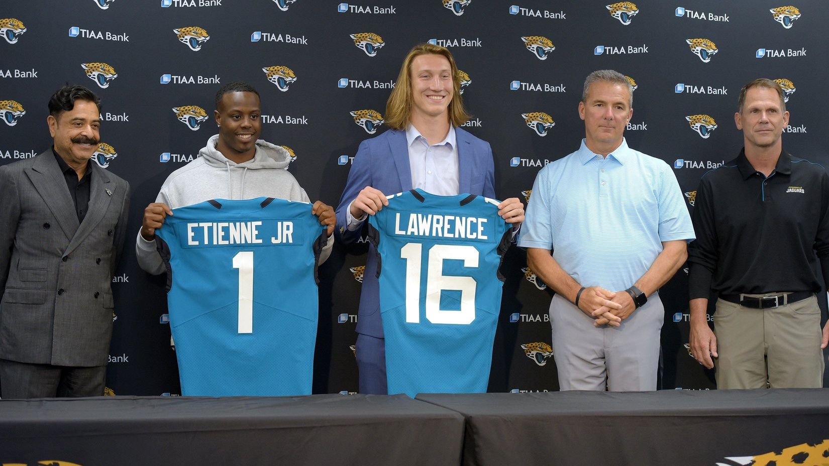 Jacksonville Jaguars 2021 first-round picks, QB Trevor Lawrence (16) and RB Travis Etienne Jr. (1), pose for pictures with the Jaguars' front office.