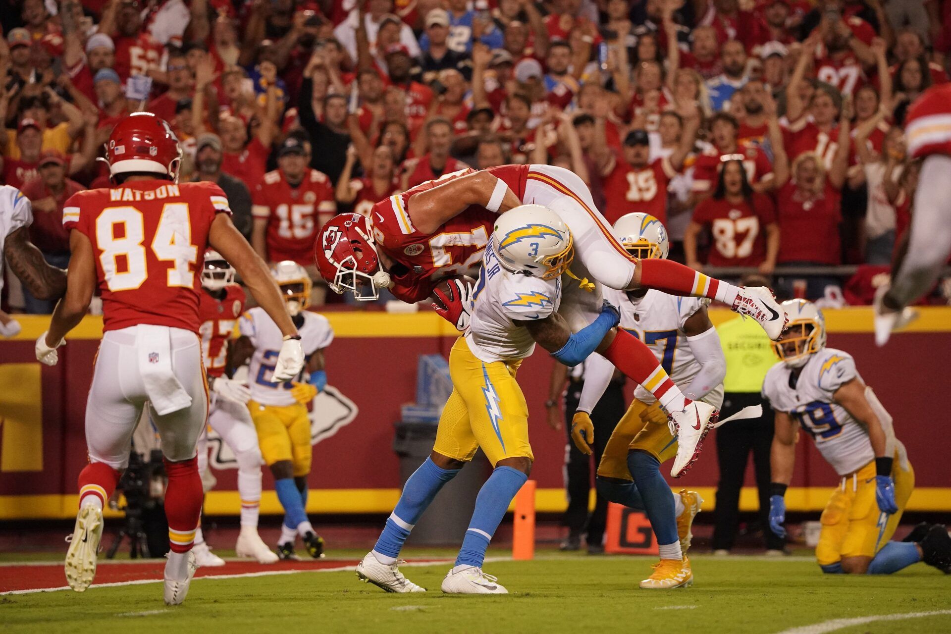 Kansas City Chiefs tight end Travis Kelce (87) is brought down by Los Angeles Chargers safety Derwin James Jr. (3) during the second half at GEHA Field at Arrowhead Stadium.