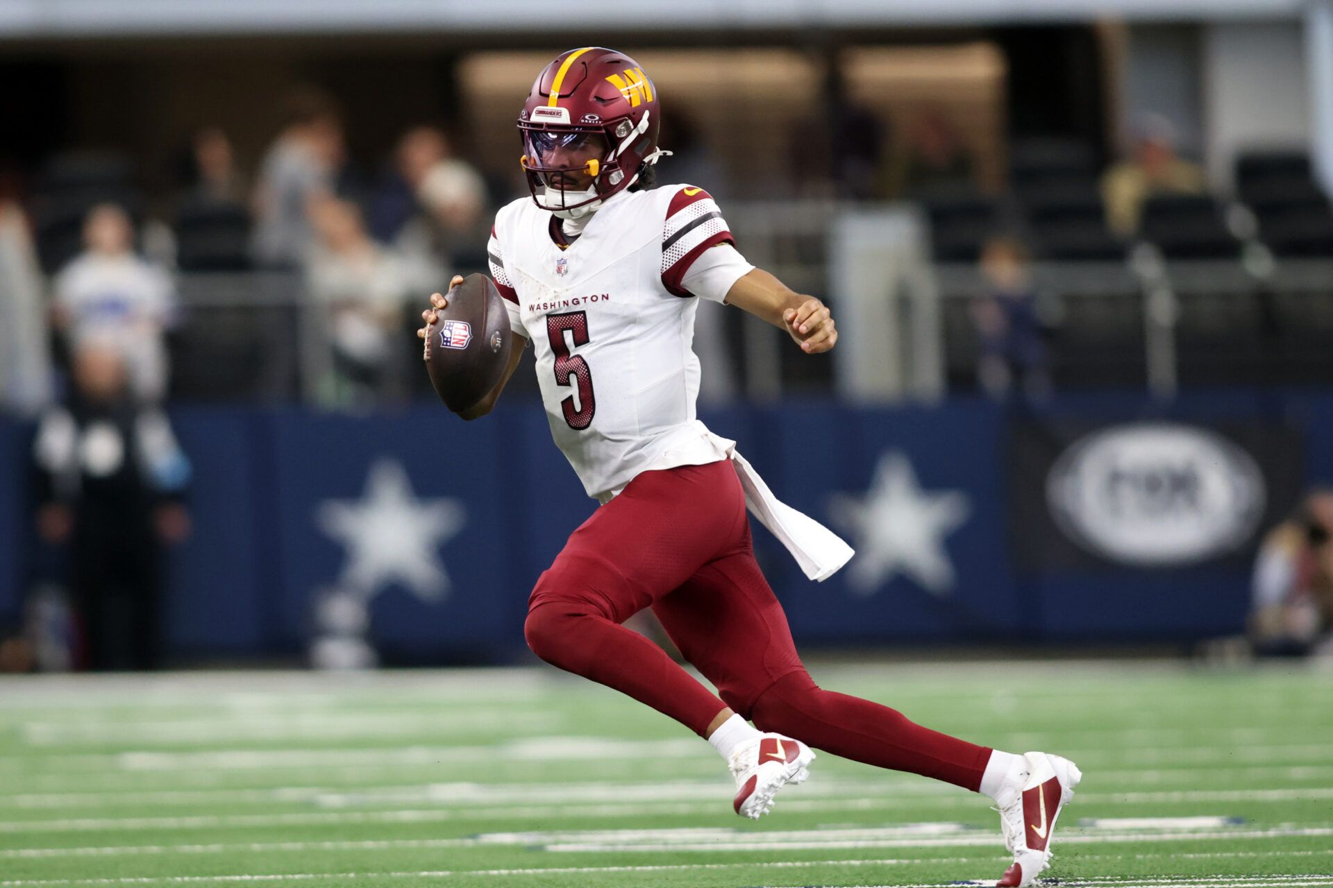 Jan 5, 2025; Arlington, Texas, USA; Washington Commanders quarterback Jayden Daniels (5) runs the ball against the Dallas Cowboys during the second quarter at AT&T Stadium. Mandatory Credit: Tim Heitman-Imagn Images