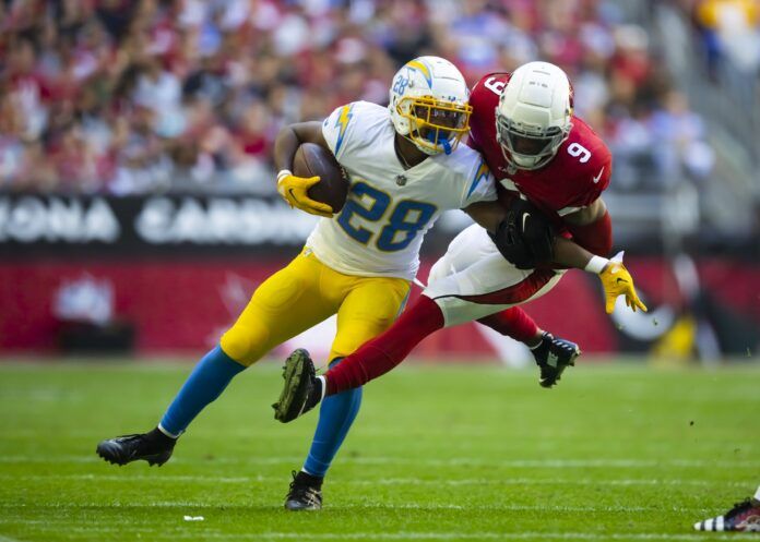 RB Isaiah Spiller attempts to evade a tackle against the Arizona Cardinals.