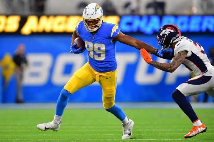 Donald Parham Jr. runs the ball against Denver Broncos safety Justin Simmons.