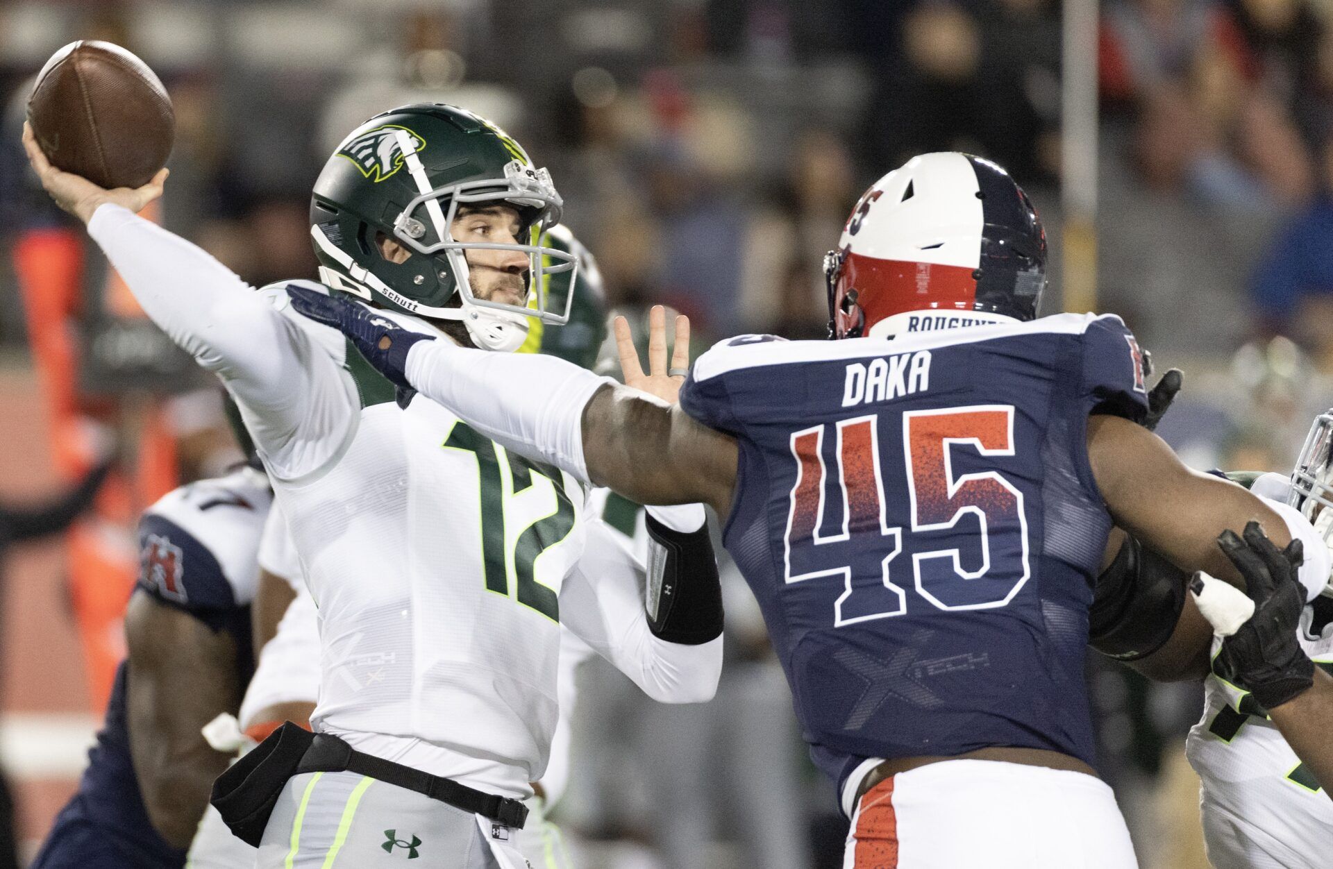 Orlando Guardians QB Quinten Dormady (12) throws a pass as he's being hit by a Houston defender.