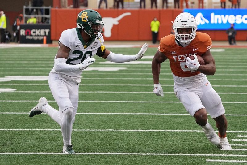 Texas running back Bijan Robinson (5) runs by a Baylor defender.