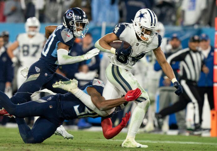 Malik Davis rushes for a first down past Tennessee Titans defenders.