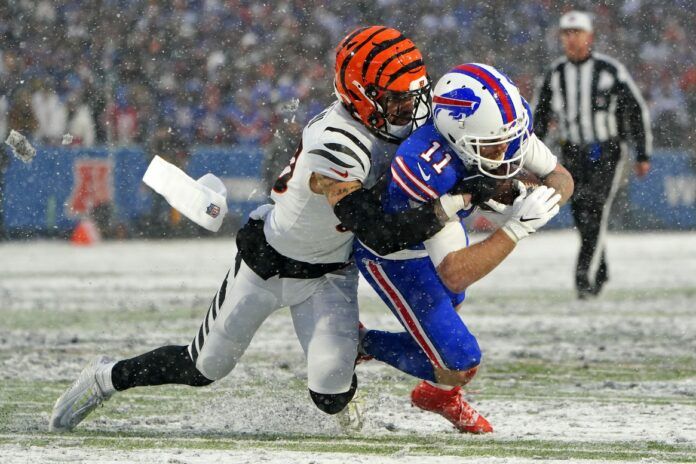 Cincinnati Bengals DB Jessie Bates III (30) tackles Bills WR Cole Beasley (11) in the snow during the Divisional Round of the playoffs.