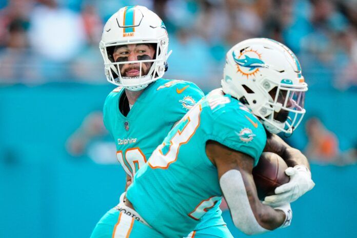 Miami Dolphins RB Jeff Wilson Jr. (23) takes a hand off from QB Skylar Thompson (19).