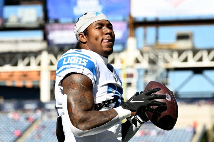 Jamaal Williams passes the ball with fans before a game against the New England Patriots.