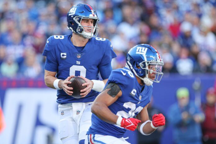 New York Giants quarterback Daniel Jones (8) drops back to pass behind running back Saquon Barkley (26).