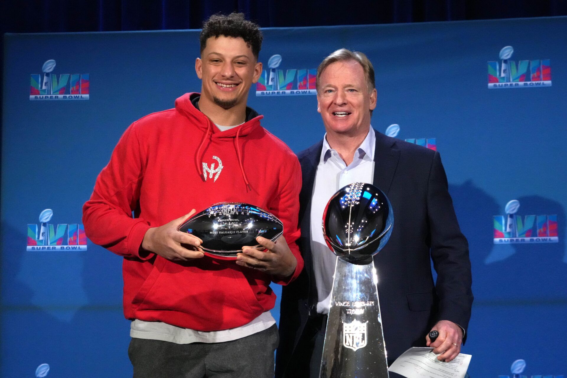 Kansas City Chiefs QB Patrick Mahomes stands with NFL Commissioner Roger Goodell with the MVP and Super Bowl trophies.