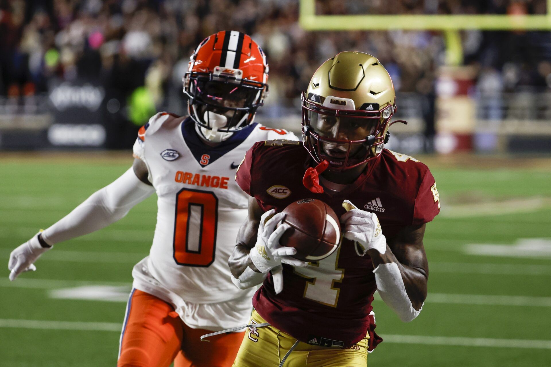 Boston College WR Zay Flowers (4) catches a pass behind Syracuse defender Darian Chestnut (0).