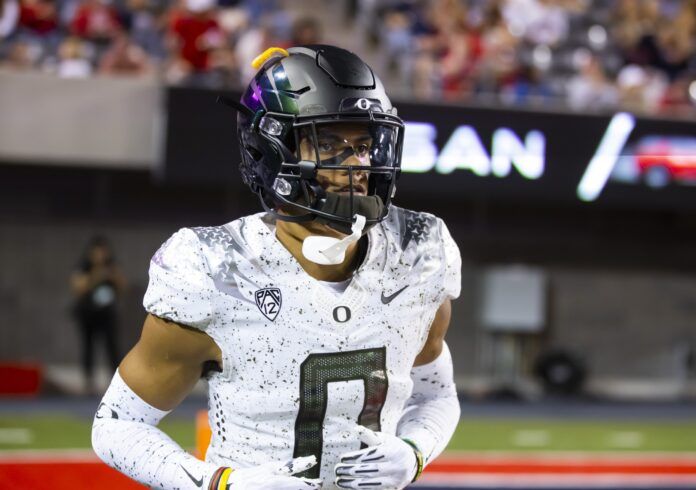 Oregon CB Christian Gonzalez jogs on the sidelines.