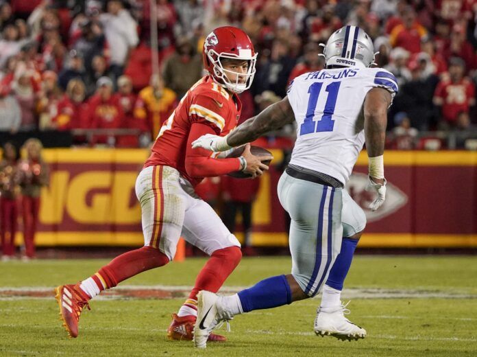 Kansas City Chiefs quarterback Patrick Mahomes (15) looks to pass as Dallas Cowboys outside linebacker Micah Parsons (11) defends during the game at GEHA Field at Arrowhead Stadium.