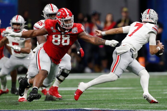 Ohio State quarterback C.J. Stroud escapes a tackle from Georgia defensive lineman Jalen Carter.