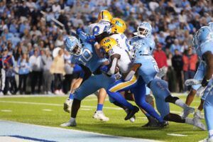 Pittsburgh Panthers running back Israel Abanikanda (2) scores a touchdown as North Carolina Tar Heels defensive lineman Desmond Evans (10) defensive back Don Chapman (2) defend in the second quarter at Kenan Memorial Stadium.