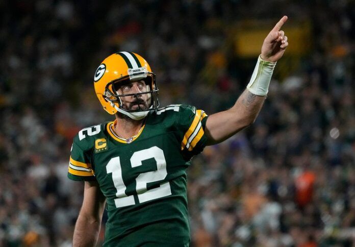 Green Bay Packers QB Aaron Rodgers (12) points to the crowd in celebration.