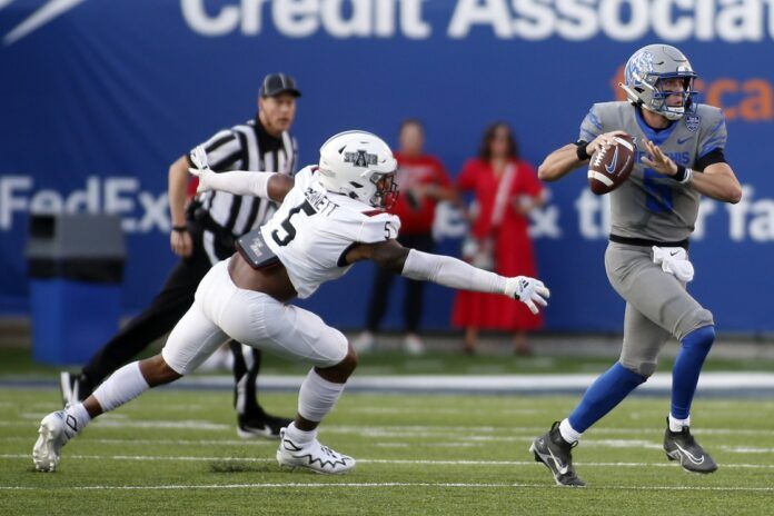 Memphis Tigers quarterback Seth Henigan (5) scrambles away from Arkansas State Red Wolves linebacker Kivon Bennett (5).