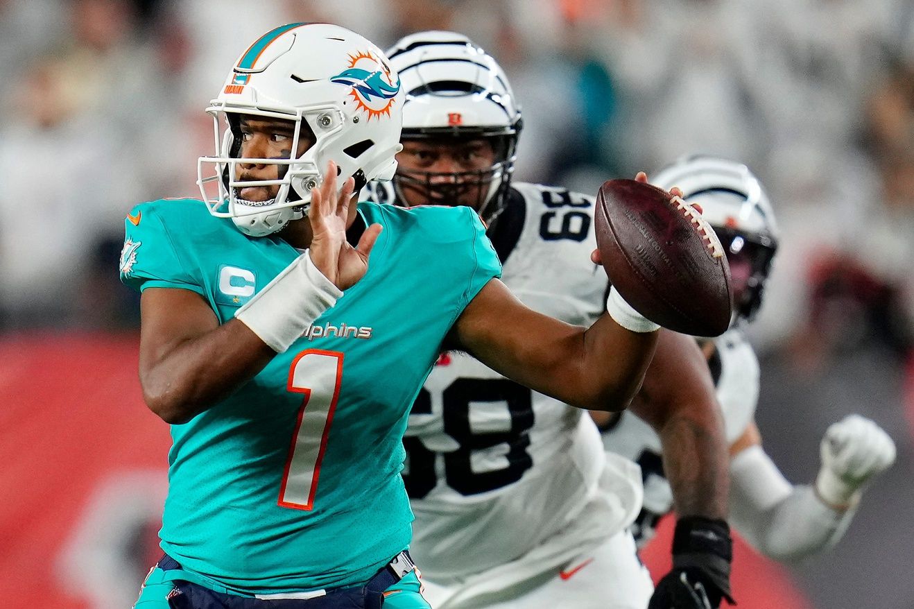 Miami Dolphins QB Tua Tagovailoa (1) looks to throw with Cincinnati Bengals DT Josh Tupou (68) in pursuit.