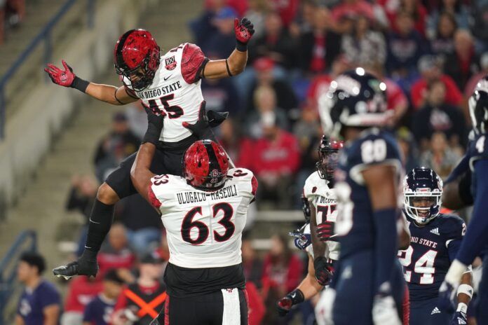 Jesse Matthews (45) celebrates with offensive lineman Ross Ulugalu-Maseuli (63) after scoring a touchdown.