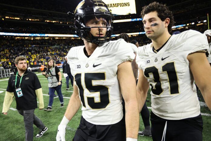 Charlie Jones (15) and Purdue Boilermakers long snapper Nick Zecchino (31) walk off the field.