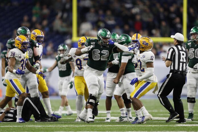 Pittsburgh Panthers defensive back Paris Ford (12) grabs the facemask of Eastern Michigan Eagles offensive lineman Sidy Sow (62) during the fourth quarter at Ford Field.