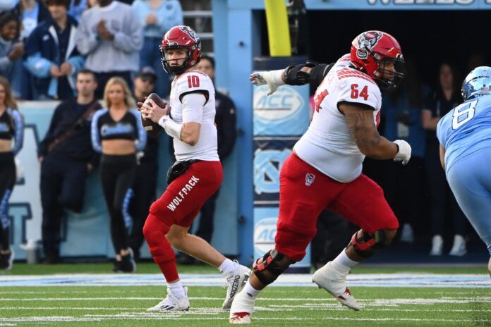 Chandler Zavala (64) blocks and North Carolina Tar Heels defensive lineman Myles Murphy (8) pressures.