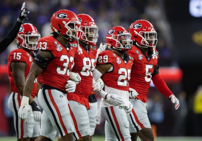 Robert Beal, Jr. (33), defensive lineman Jalen Carter (88), Christopher Smith and defensive back Kelee Ringo (5) lock arms as they exit the game.