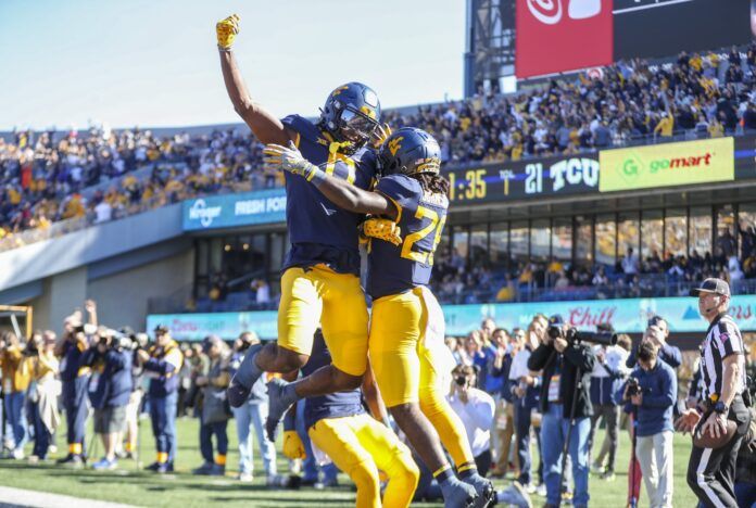 Justin Johnson Jr. (26) scores a touchdown and celebrates with West Virginia Mountaineers wide receiver Bryce Ford-Wheaton.