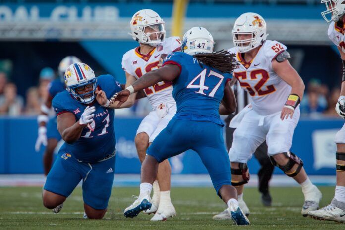 Iowa State Cyclones quarterback Hunter Dekkers (12) is sacked by Kansas Jayhawks defensive end Lonnie Phelps (47).