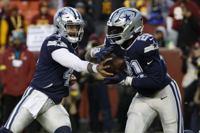 Dak Prescott (4) hands the ball off to Cowboys running back Ezekiel Elliott (21) against the Washington Commanders.