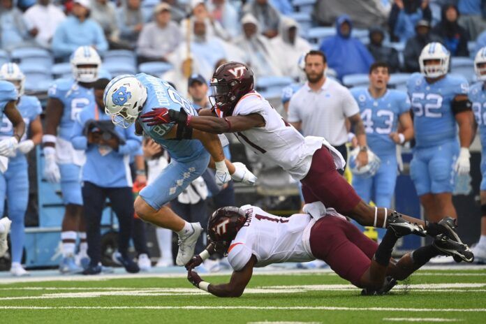 North Carolina Tar Heels tight end John Copenhaver (81) is tackled by Virginia Tech Hokies linebacker Keli Lawson (21) and defensive back Chamarri Conner (1).