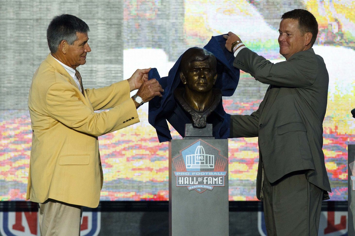 Chris Hanburger is presented his bust at the Pro Football Hall of Fame by his son in 2011.