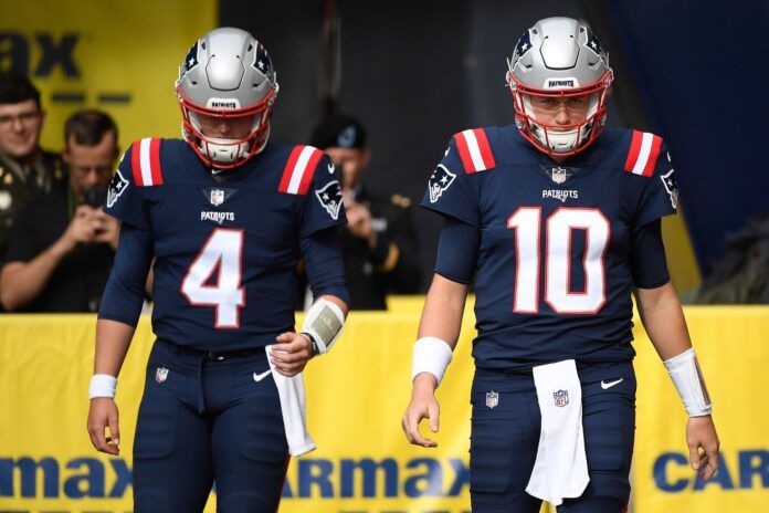 New England Patriots quarterbacks Bailey Zappe (4) and Mac Jones (10) walk onto the field.