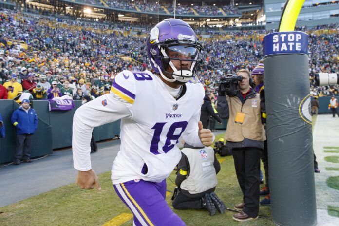 Minnesota Vikings WR Justin Jefferson (18) runs onto the field at Lambeau Field.