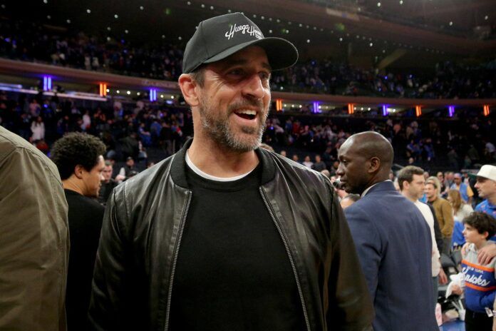 New York Jets QB Aaron Rodgers walks off the court after a basketball game between the New York Knicks and the Miami Heat.