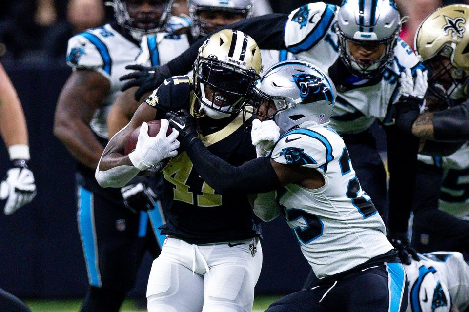 Carolina Panthers safety Xavier Woods (25) tackles New Orleans Saints running back Alvin Kamara (41) during the first half at Caesars Superdome. 