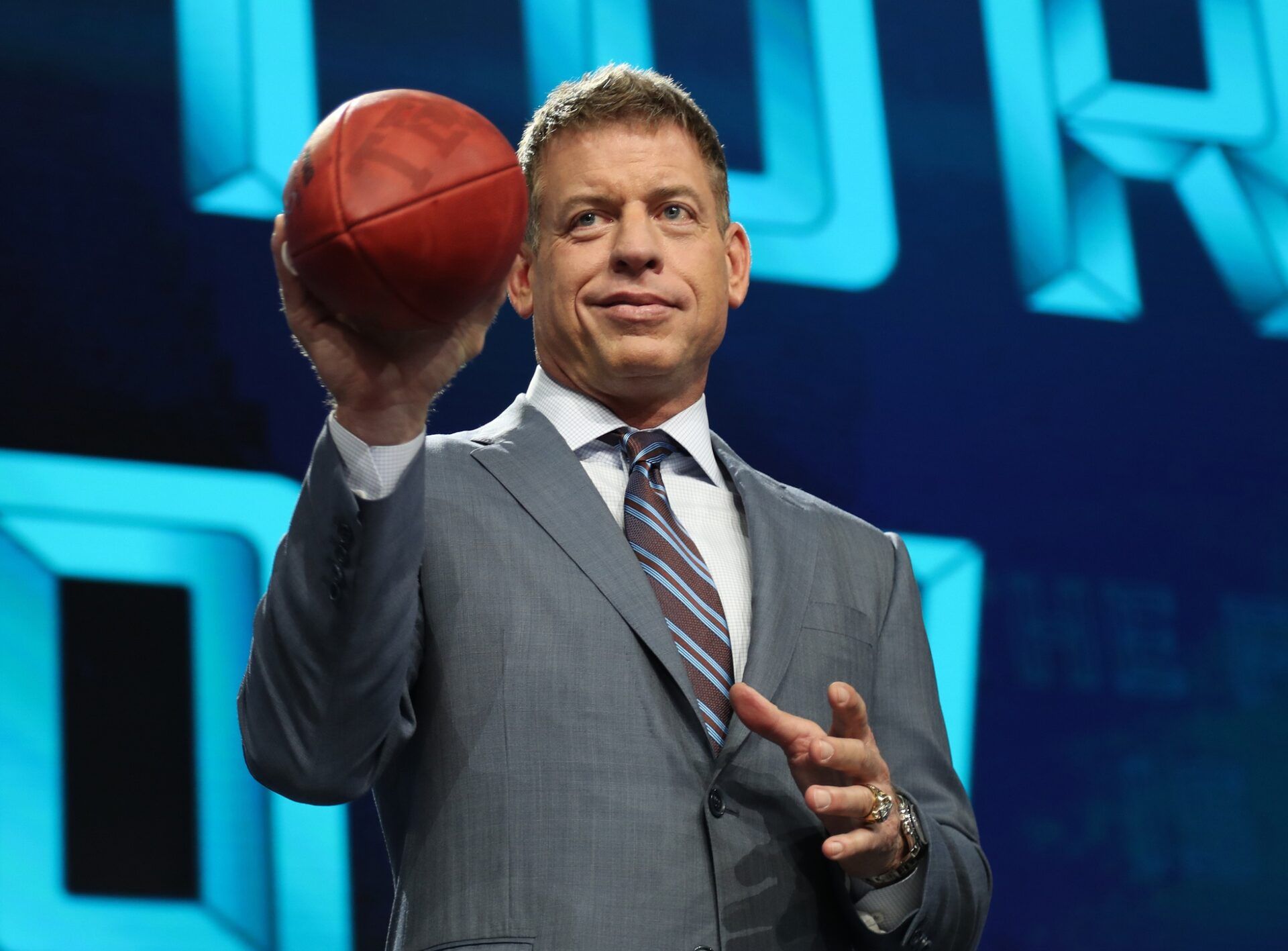 Troy Aikman throws a football from the stage prior to the first round of the 2018 NFL Draft.