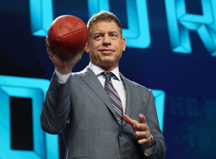 Troy Aikman throws a football from the stage prior to the first round of the 2018 NFL Draft.