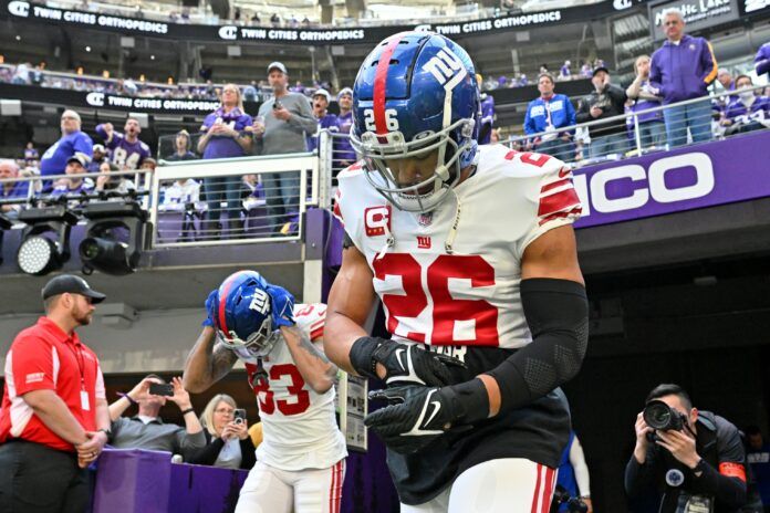 Saquon Barkley (26) runs onto the field before a Wild Card game against the Minnesota Vikings at U.S. Bank Stadium.