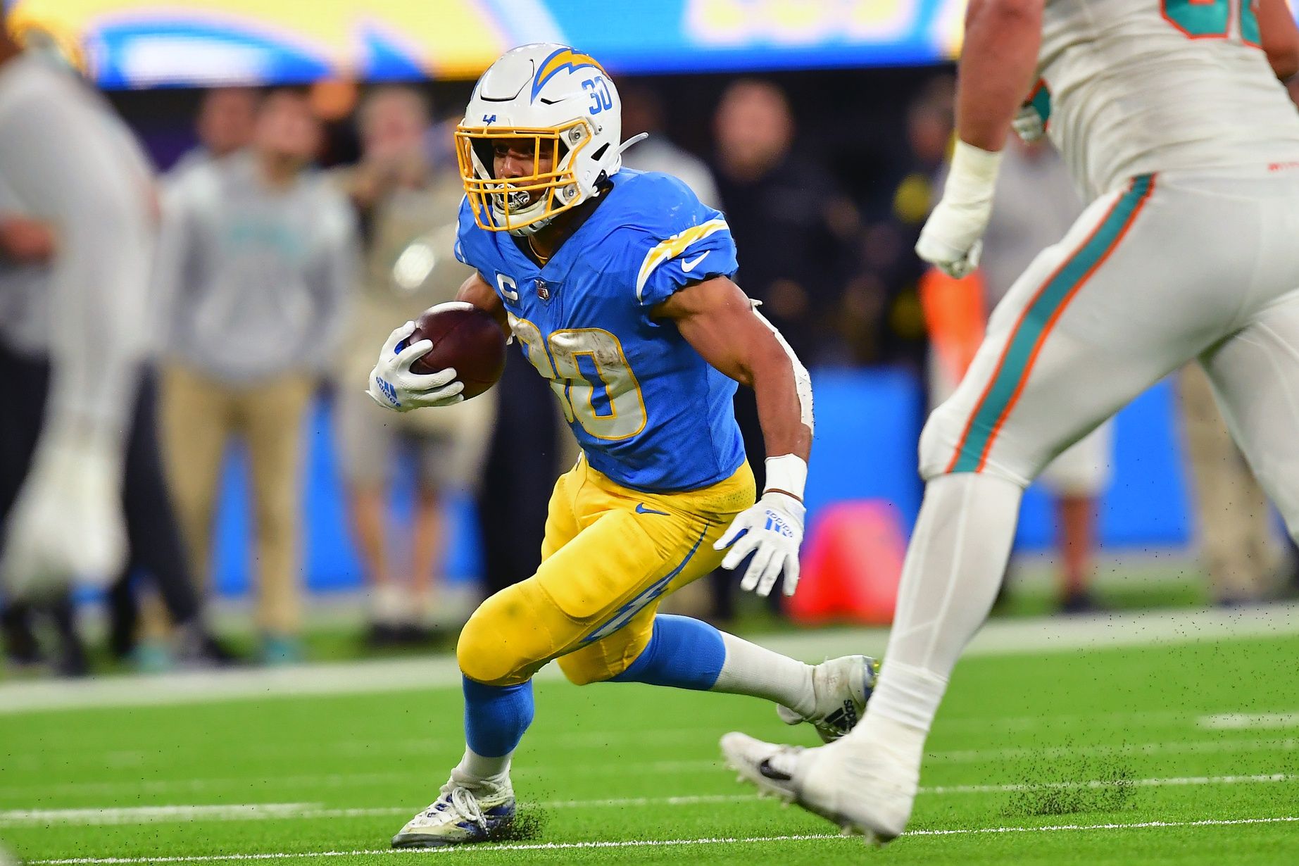 Austin Ekeler (30) runs the ball against the Miami Dolphins during the second half at SoFi Stadium.