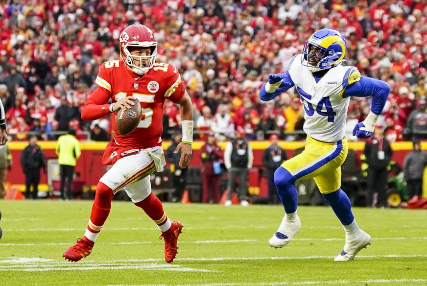 Patrick Mahomes (15) scrambles from Los Angeles Rams linebacker Leonard Floyd (54) during the first half at GEHA Field at Arrowhead Stadium.