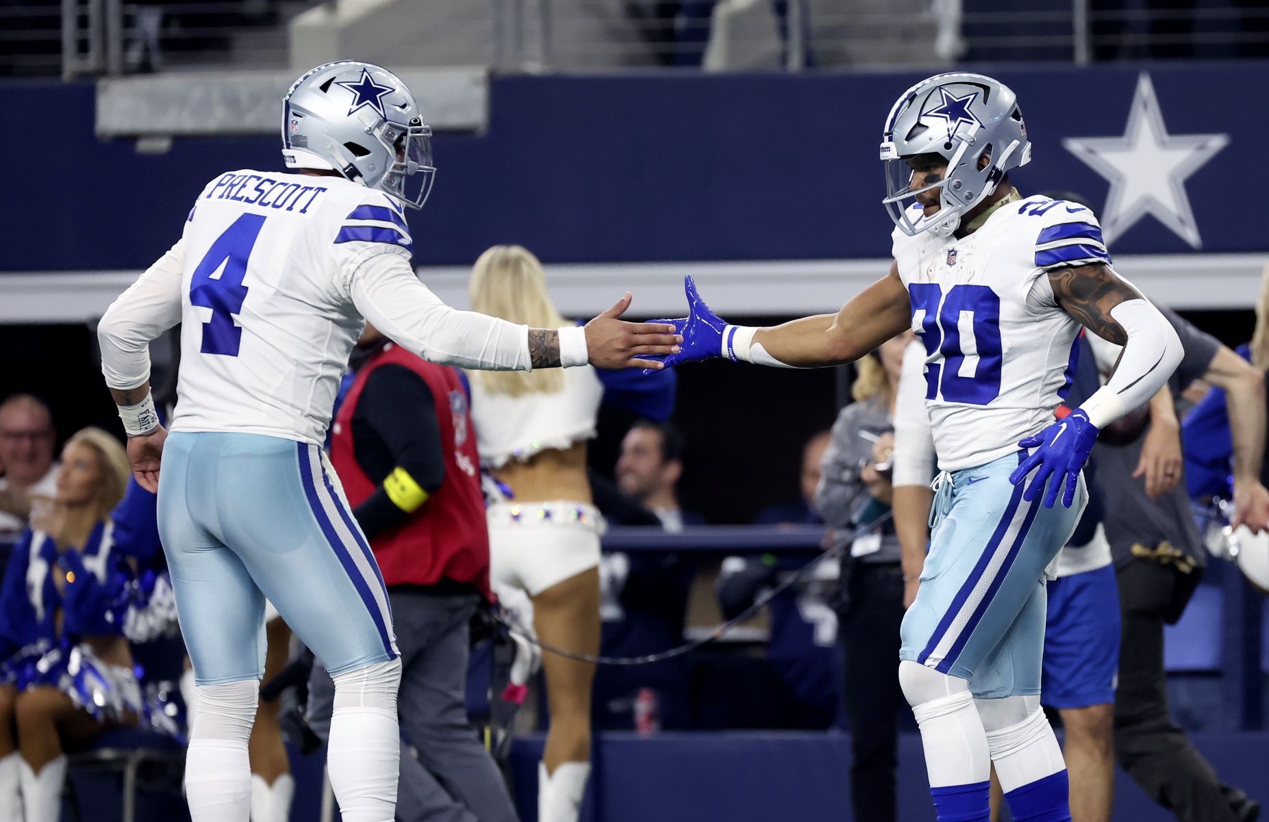 Dallas Cowboys QB Dak Prescott (4) and RB Tony Pollard (20) celebrate after a touchdown.