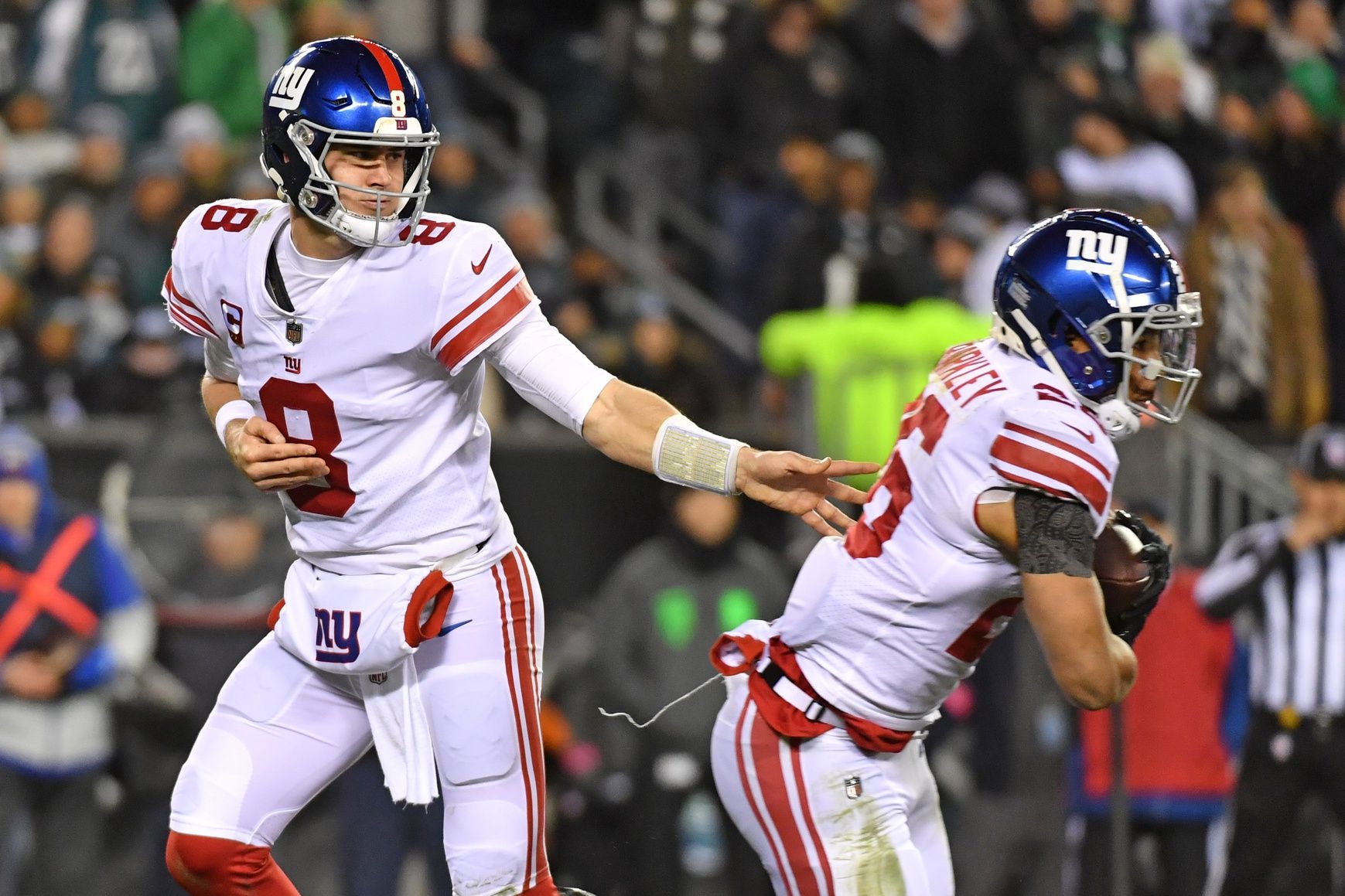 Daniel Jones (8) hands the ball to running back Saquon Barkley (26) against the Philadelphia Eagles during an NFC Divisional Round game at Lincoln Financial Field.