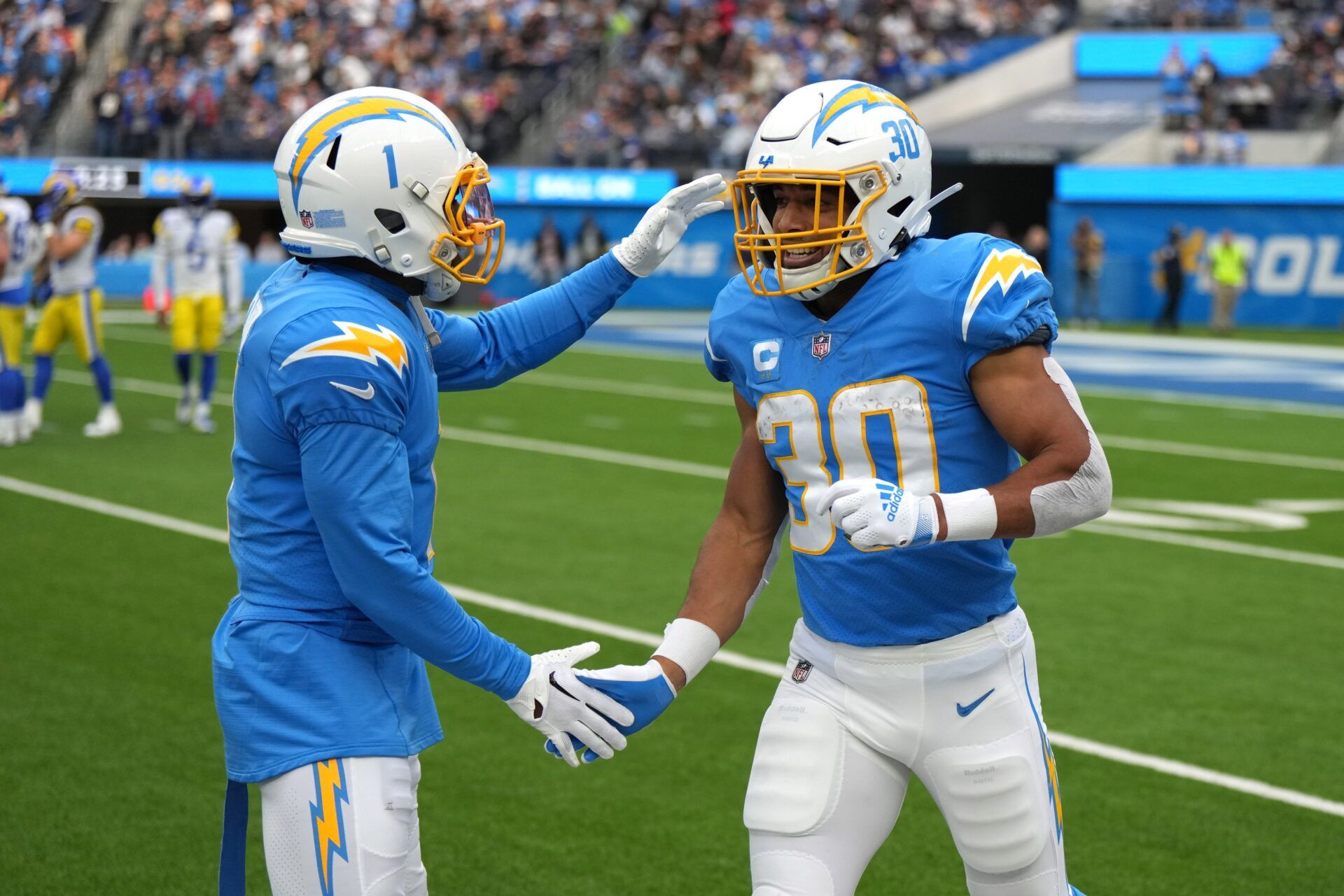 Los Angeles Chargers running back Austin Ekeler (30) celebrates with wide receiver DeAndre Carter (1) after scoring a touchdown against the Los Angeles Rams in the first half at SoFi Stadium.