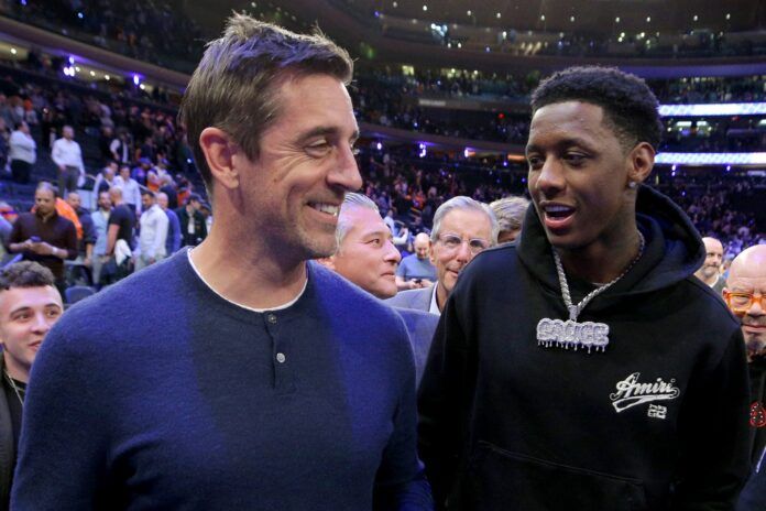 New York Jets QB Aaron Rodgers and CB Sauce Gardner walk off the court after the Knicks-Heat conference semifinal matchup.