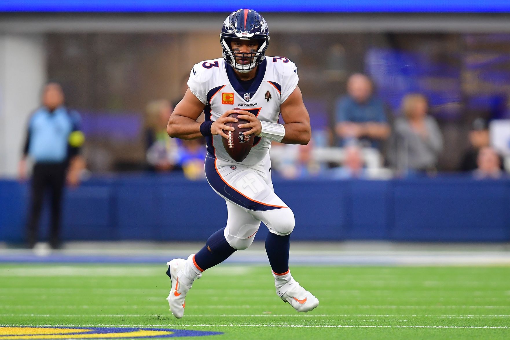 Denver Broncos QB Russell Wilson (3) rolls out to make a pass.