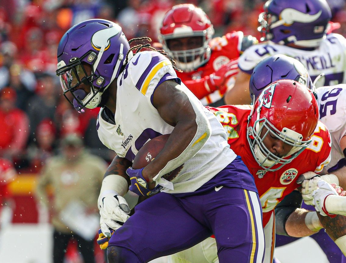 Minnesota Vikings running back Dalvin Cook (33) is tackled by Kansas City Chiefs defensive tackle Mike Pennel (64) during the second half at Arrowhead Stadium. 