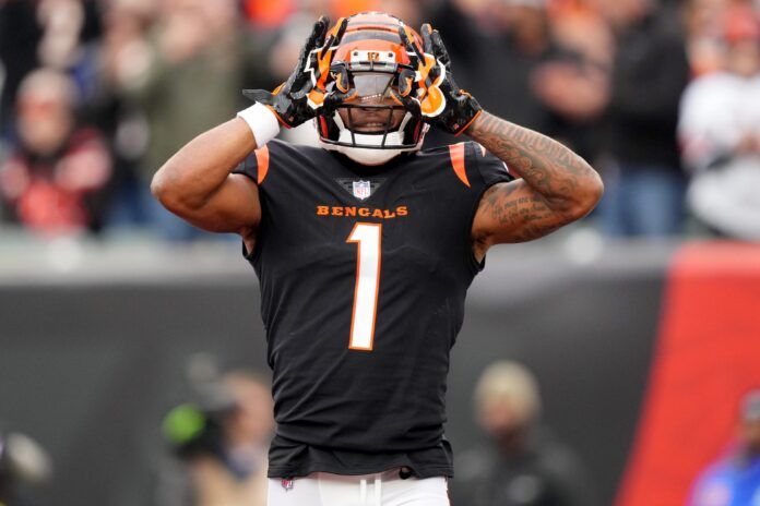 Cincinnati Bengals WR Ja'Marr Chase (1) lifts his hands to his helmet in celebration after scoring a touchdown.