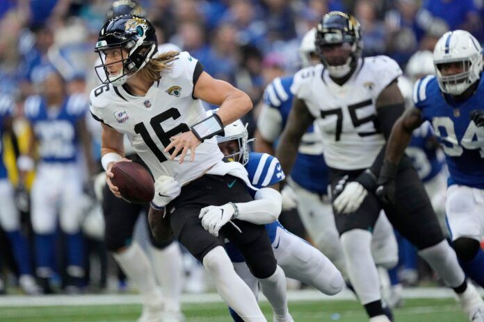 Jacksonville Jaguars QB Trevor Lawrence (16) tries to run away from the Colts' defense.